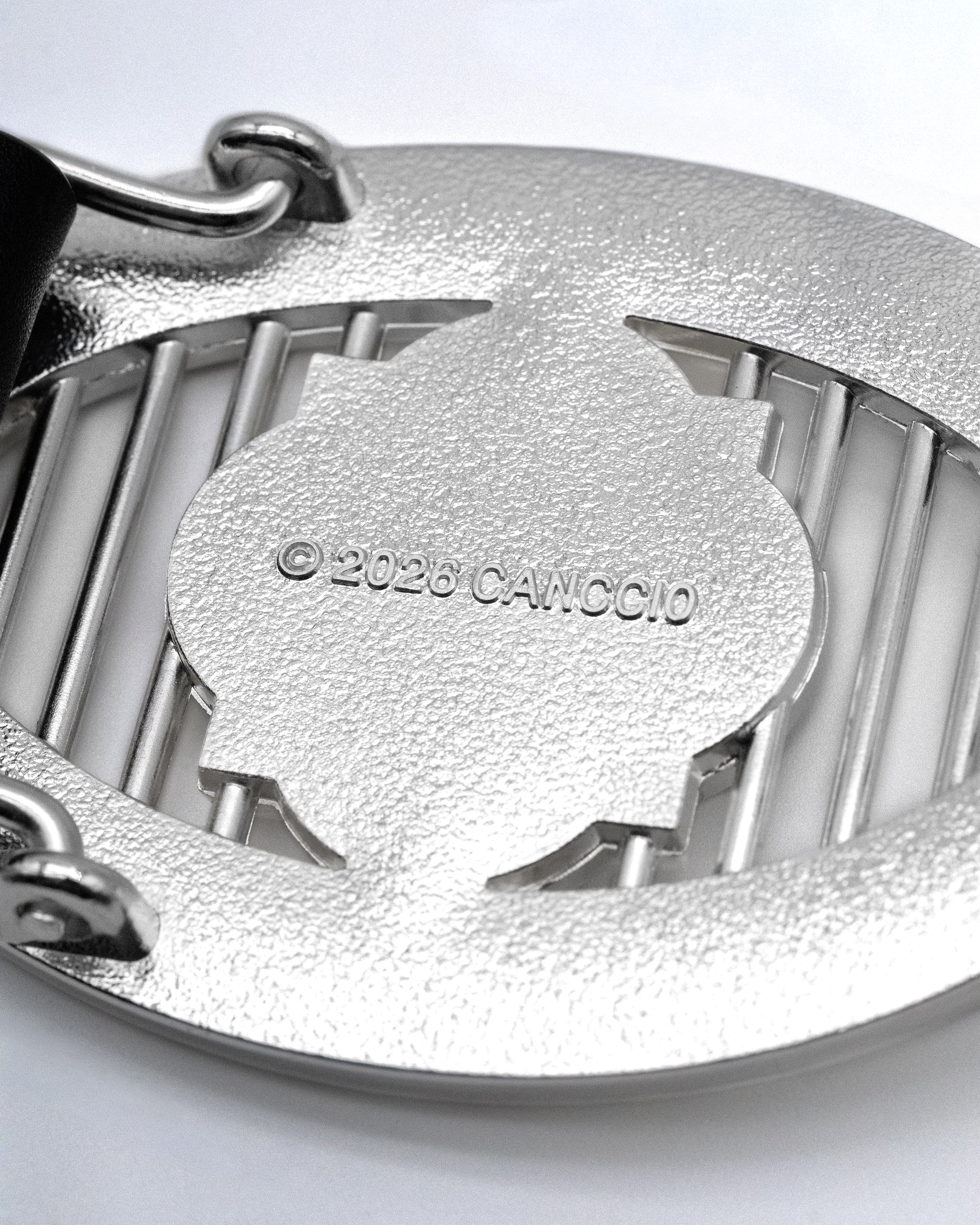 CANCCIO ORNA silver buckle close up with embossed branding engravement, texture backside close up